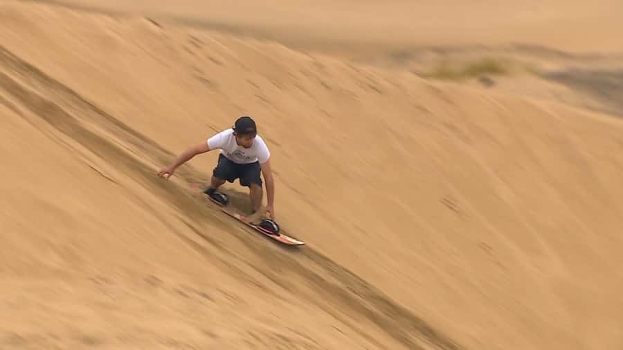 Explore desert Qatar: Off-Road Adventures, dune bashing Tour - Sandboarding from a high dune