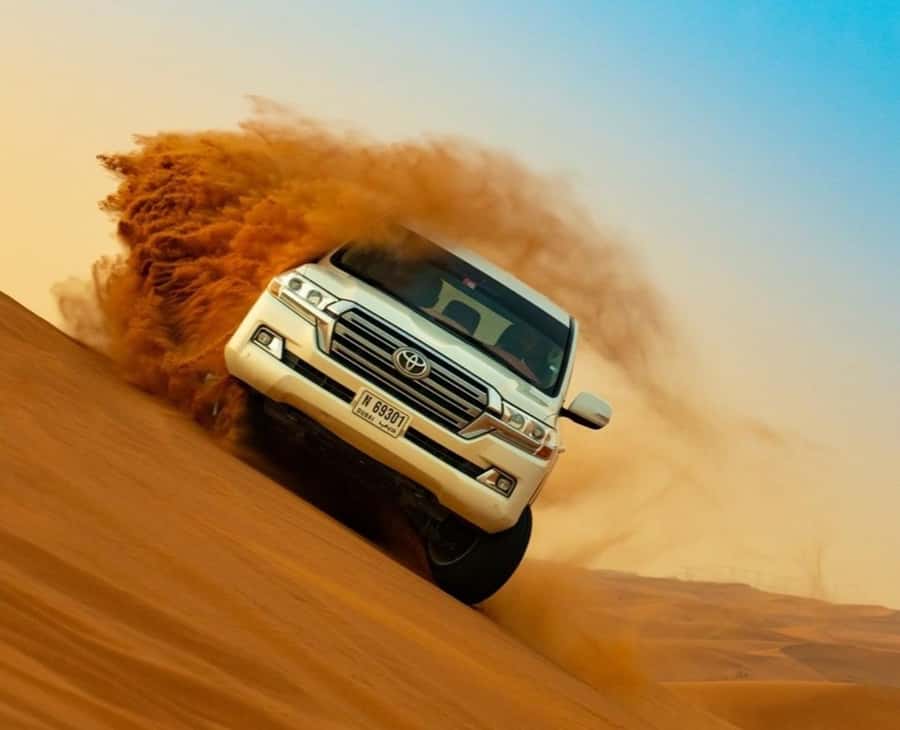Qatar: Sunset Desert Safari with Camel Ride & Sandboarding - Dune bashing on the way to sunset